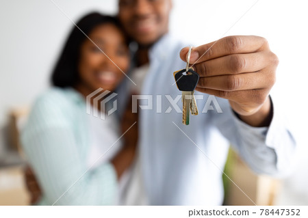 New home owners. Happy african american couple holding home keys, celebrating buying new flat, selective focus 78447352