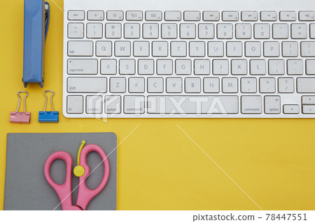 Digital learning concept. Top view of notebook and school suppliers and wireless keyboard isolated on yellow Digital learning concept. Top view of notebook and school suppliers and wireless keyboard isolated on yellow 78447551