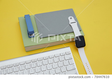 Digital learning concept . Top view of book, school supplier , wireless keyboard and smartwatch isolated on yellow	 78447610