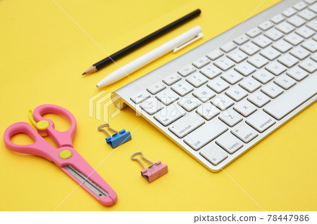 Digital learning concept. Top view of notebook and school suppliers and wireless keyboard isolated on yellow Digital learning concept. Top view of notebook and school suppliers and wireless keyboard isolated on yellow 78447986