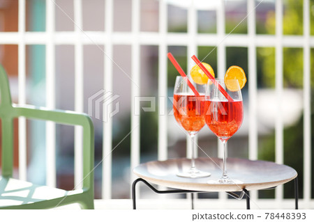 Two orange cocktails with straw on wooden table Two orange cocktails with straw on wooden table 78448393