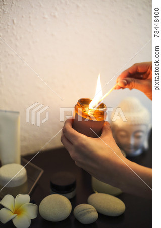 Crop person lighting aromatic candle 78448400