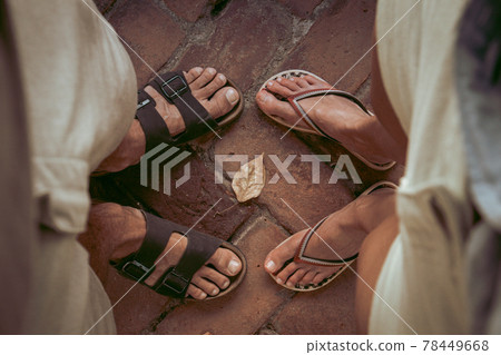 Top down view of man and woman wearing sandals and flip flops facing eachother. Summertime, adventure, backpacking, traveling concept. 78449668