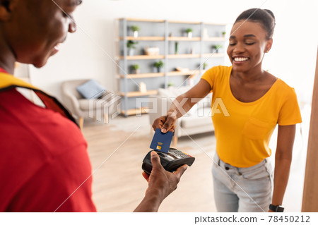 African Female Paying With Credit Card Standing With Courier Indoor African Female Paying With Credit Card Standing With Courier Indoor 78450212