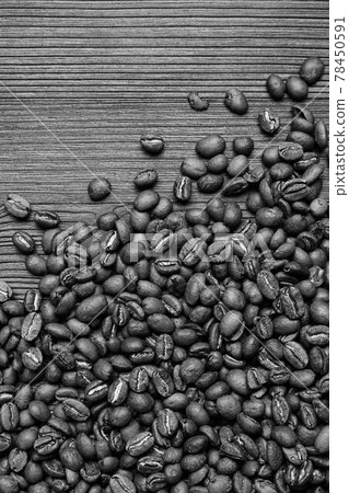 Scattered coffee beans on a wooden background. Black and white photo. Scattered coffee beans on a wooden background. Black and white photo. 78450591