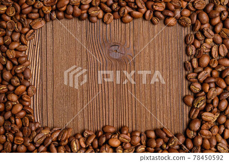 Coffee beans make a frame for a place with text on a wooden background. Coffee beans make a frame for a place with text on a wooden background. 78450592