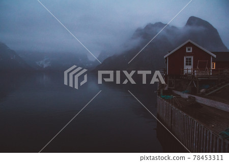 Norway rorbu houses and mountains rocks over fjord landscape scandinavian travel view Lofoten islands. Night landscape. Norway rorbu houses and mountains rocks over fjord landscape scandinavian travel view Lofoten islands. Night landscape. 78453311