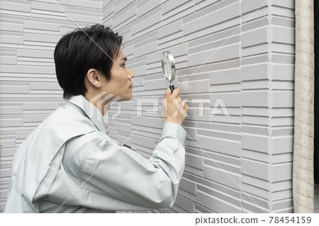 推銷員用放大鏡檢查外牆 推銷員用放大鏡檢查外牆 78454159