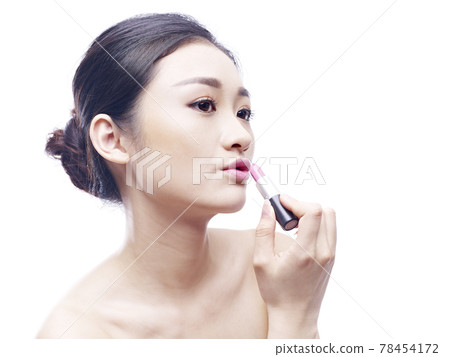 young asian woman applying lipstick, isolated on white background. young asian woman applying lipstick, isolated on white background. 78454172