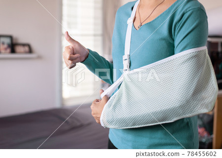 Patient woman wearing arm sling for relieve broken arms at home Patient woman wearing arm sling for relieve broken arms at home 78455602