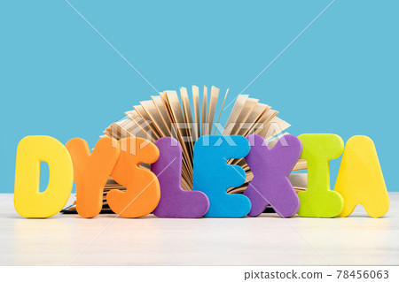 Dyslexia concept, word on a desk with pile of books 78456063