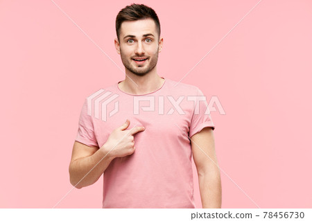 Amazed young man looking surprised pointing himself, making sure he heard righ over pink background 78456730