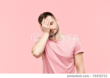 Tired disappointed young man with face palm gesture over pink background 78456732