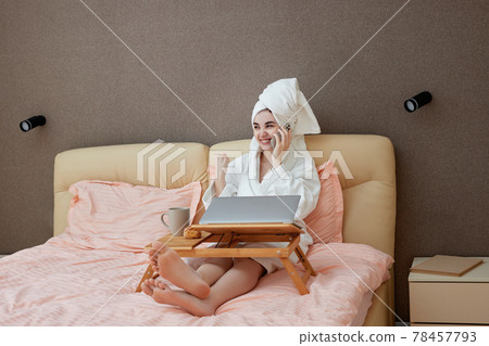 young beautiful caucasian woman in white bathrobes and towels on heads young beautiful caucasian woman in white bathrobes and towels on heads 78457793