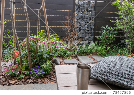 Coffee break on the wooden deck (veranda) in a small garden with a gabion 78457896
