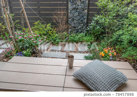 Coffee break on the wooden deck (veranda) in a small garden with a gabion Coffee break on the wooden deck (veranda) in a small garden with a gabion 78457898