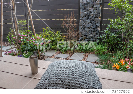 Coffee break on the wooden deck (veranda) in a small garden with a gabion 78457902