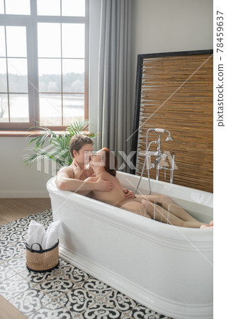 A man and a woman having a bath together and looking enjoyed A man and a woman having a bath together and looking enjoyed 78459637