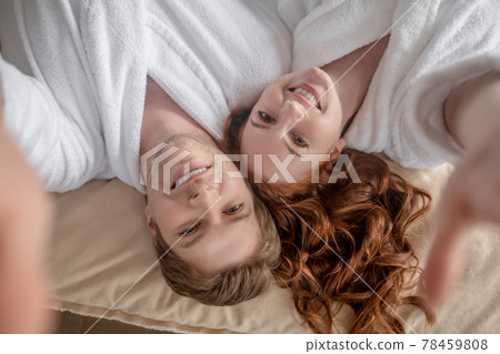 Happy man and woman lying in bed and smiling 78459808