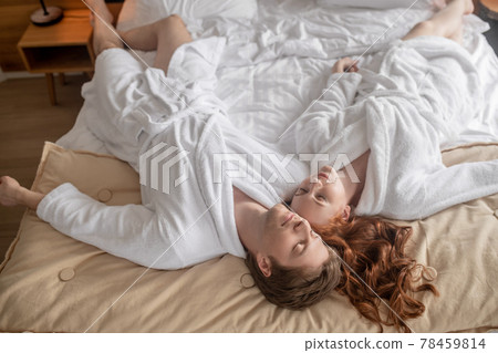 A man and a woman in white looking relaxed and peaceful 78459814