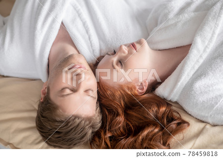 A man and a woman in white looking relaxed and peaceful A man and a woman in white looking relaxed and peaceful 78459818