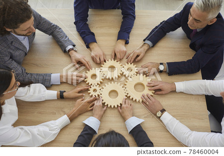 Team of business people connect some gearwheels as metaphor for effective teamwork 78460004