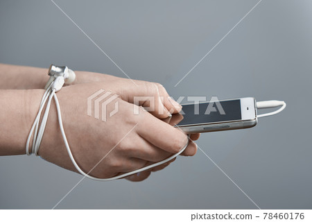 Female hands and smartphone. Addiction to internet and social networks. Hands tied with wire. Female hands and smartphone. Addiction to internet and social networks. Hands tied with wire. 78460176