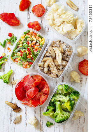 Stocks of food for the winter. Container with frozen vegetables and mushrooms. Top view flat lay background. Stocks of food for the winter. Container with frozen vegetables and mushrooms. Top view flat lay background. 78460315