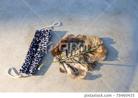 A used and dirty medical mask to protect against the corona virus lies in a city park like trash. The mask clears from the coronavirus infection COVID-19 78460435