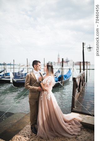 Gorgeous happy couple standing close to each other and looking in eyes in Venice, Italy Gorgeous happy couple standing close to each other and looking in eyes in Venice, Italy 78460456