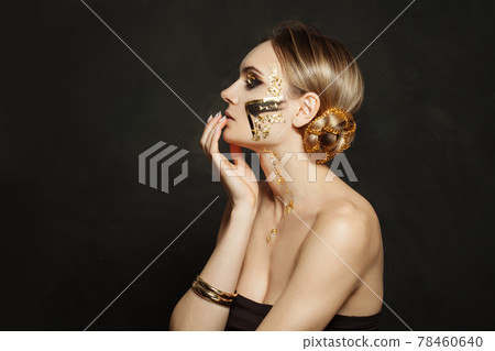 Nice woman with golden makeup on black background Nice woman with golden makeup on black background 78460640