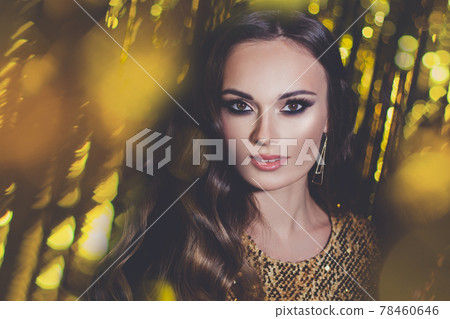 Beautiful woman face. Celebrity model with makeup on gold bokeh background Beautiful woman face. Celebrity model with makeup on gold bokeh background 78460646