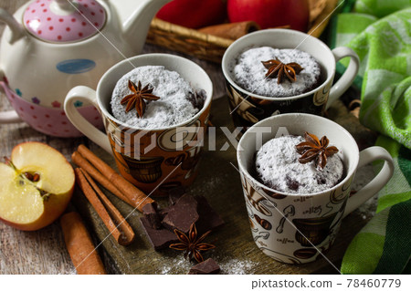 Quick autumn dessert. Autumn apple pie mugcake with red apples and spices on a rustic background. 78460779