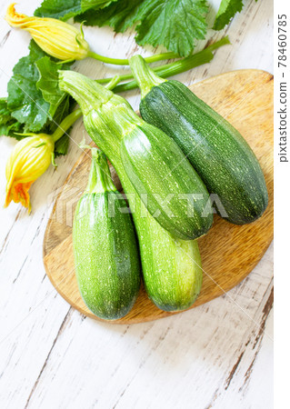 Fresh healthy uncooked green zucchini on a wooden kitchen table. Diet menu concept. Copy space. 78460785