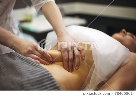 Young woman having stomach massage Young woman having stomach massage 78460861