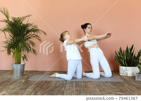 Smiling mother and daughter practicing yoga together Smiling mother and daughter practicing yoga together 78461367
