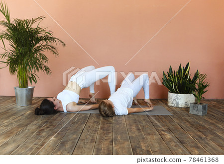 Smiling mother and daughter practicing yoga together Smiling mother and daughter practicing yoga together 78461368