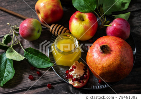 Rosh hashanah (hashana) - jewish new year holiday concept. Traditional symbols: honey, fresh apples and pomegranate on a wooden table. Rosh hashanah (hashana) - jewish new year holiday concept. Traditional symbols: honey, fresh apples and pomegranate on a wooden table. 78461392
