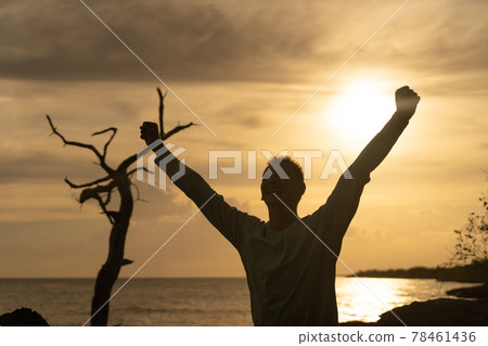 Happy exited Man full of positive emotion on sea and Beautiful Sunrise background. Happiness, joy and success concept Happy exited Man full of positive emotion on sea and Beautiful Sunrise background. Happiness, joy and success concept 78461436