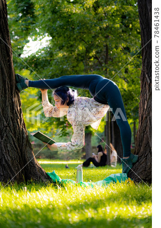 Young flexible woman read book on picnic. Knowledge, studying and learning concept Young flexible woman read book on picnic. Knowledge, studying and learning concept 78461438