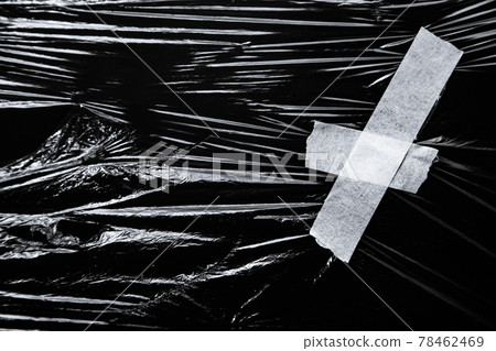 Photo of the polyethylene wrap with white tape on black background Photo of the polyethylene wrap with white tape on black background 78462469