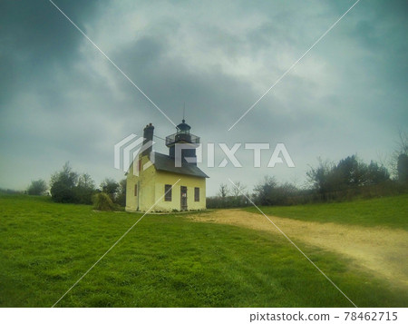 Small picturesque lighthouse on a hilltop by the sea with a dirt road leading up to it under a Small picturesque lighthouse on a hilltop by the sea with a dirt road leading up to it under a 78462715