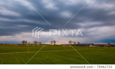 Aerial view of an evening sky over the fields overcast with thunder storm clouds coming in on the Aerial view of an evening sky over the fields overcast with thunder storm clouds coming in on the 78462720