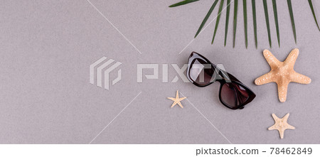 Beach accessories: glasses and hat with shells and sea stars on a colored background. Summer background Beach accessories: glasses and hat with shells and sea stars on a colored background. Summer background 78462849