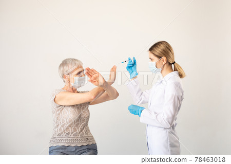 Doctor with syringe and elderly woman against coronavirus vaccination. 78463018