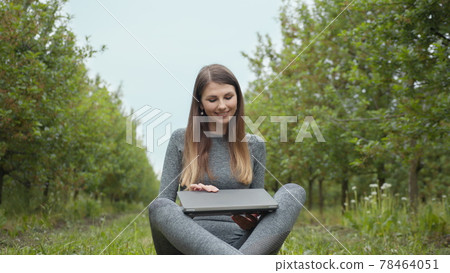IT specialist working at self isolation outdoors. Women engaging in business or freelance at nature or fresh air at amazing sun light. Girl sitting in park or forest, opening laptop on nature. 78464051