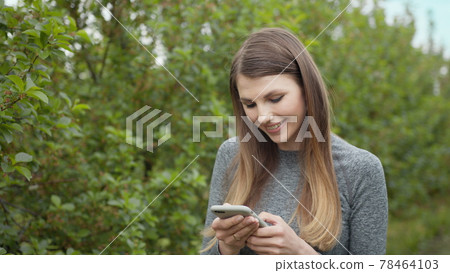 Happy young woman use smartphone standing in park sun outdoor health hand girl tree sport fitness summer nature internet technology female runner exercise phone workout mobile cell phone Happy young woman use smartphone standing in park sun outdoor health hand girl tree sport fitness summer nature internet technology female runner exercise phone workout mobile cell phone 78464103