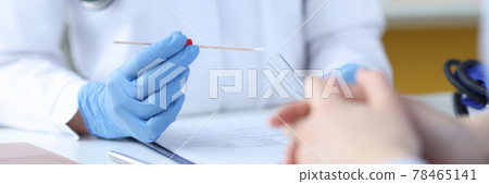 A doctor in protective gloves holds a test tube in front of a patient A doctor in protective gloves holds a test tube in front of a patient 78465141