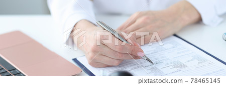 Doctor filling out patients medical history in clinic closeup 78465145