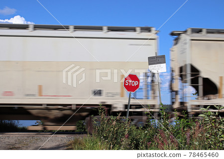 A train speeds past a stop sign at a crossing 78465460